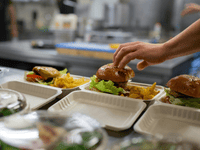 This scenario captures a moment of active food preparation and positive interaction in a professional kitche