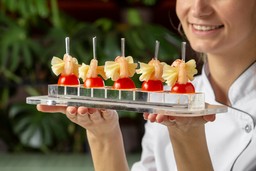 A chef serves food on a tray. Photo: Freepik.